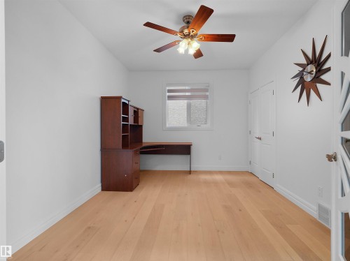 Bright room featuring light wood-finish flooring, a ceiling fan with integrated lighting, white baseboards, and a window with blinds - 3136 35 Avenue Nw, Edmonton, AB - Indoor Photo Showing Other Room
