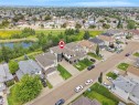 Expansive residential area featuring a distinct property with an attached garage, paved driveway, and mature landscaping - 3136 35 Avenue Nw, Edmonton, AB  - Outdoor With View 