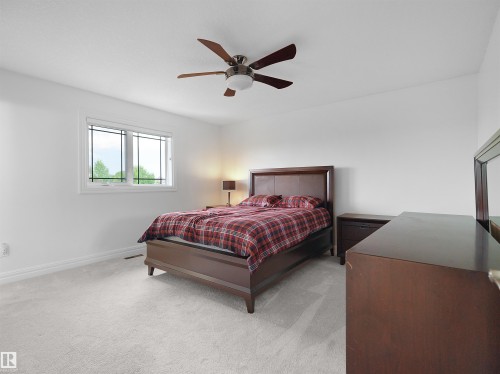 Spacious bedroom with light gray carpet flooring and white baseboards - 3136 35 Avenue Nw, Edmonton, AB - Indoor Photo Showing Bedroom