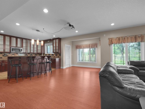 Open-concept living space featuring wood-finish flooring, recessed lighting, and a built-in kitchen island with pendant lighting - 3136 35 Avenue Nw, Edmonton, AB - Indoor Photo Showing Living Room