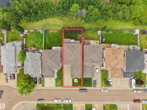 Aerial perspective of a property featuring a multi-gable roofline, a paved driveway, and a front yard with mature landscaping - 3136 35 Avenue Nw, Edmonton, AB - Outdoor With View