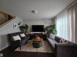 Spacious living area featuring dark wood-finish flooring and light gray walls - 
