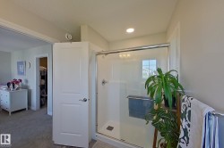 Shower enclosure with clear glass door, chrome hardware, and recessed ceiling lighting - 