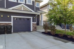 Concrete driveway leading to a single-car garage with panel detailing and upper window inserts - 