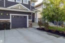 Concrete driveway leading to a single-car garage with panel detailing and upper window inserts - 491 Ebbers Way, Edmonton, AB 