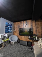 Finished ceiling with integrated lighting, wood-panel accent wall, and plush carpet flooring - 