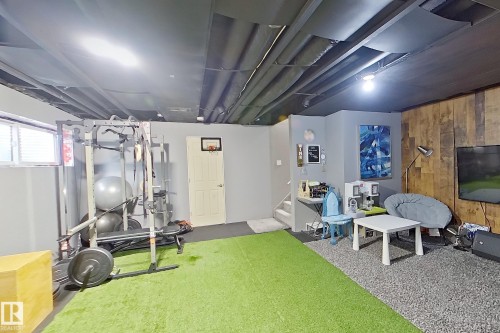 Multi-functional interior space featuring a grey painted ceiling, wall-mounted lighting, and a window with blinds - 491 Ebbers Way, Edmonton, AB 