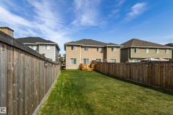 Expansive backyard with a manicured lawn, full wood fencing, and a multi-level wood deck - 