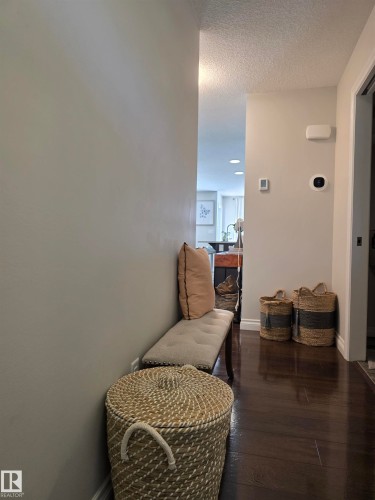Rich wood-finish flooring extending through the hallway - 491 Ebbers Way, Edmonton, AB 