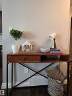 Contemporary console table featuring a wood-finish top with a single drawer and open storage, supported by a black metal frame with an X-brace design - 