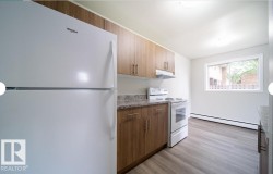 Kitchen featuring wood-finish cabinetry, granite-style countertops, and a white appliance suite - 