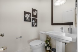 Pedestal sink with chrome faucet, complemented by a large framed mirror and recessed lighting - 