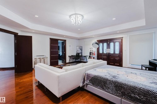 Spacious room featuring rich wood-finish flooring, recessed lighting, and a decorative ceiling fixture - 4103 Westcliff Heath Heath Sw, Edmonton, AB - Indoor Photo Showing Bedroom