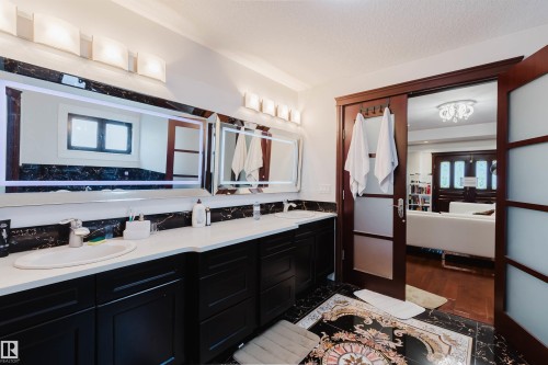 Dual vanity with integrated sinks, white countertops, and dark cabinetry - 4103 Westcliff Heath Heath Sw, Edmonton, AB - Indoor Photo Showing Bathroom