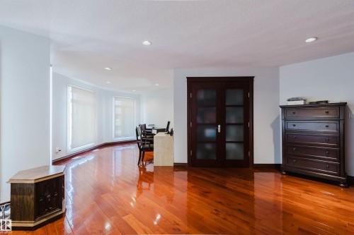 Rich wood-finish flooring extends through this open living area - 4103 Westcliff Heath Heath Sw, Edmonton, AB - Indoor Photo Showing Other Room