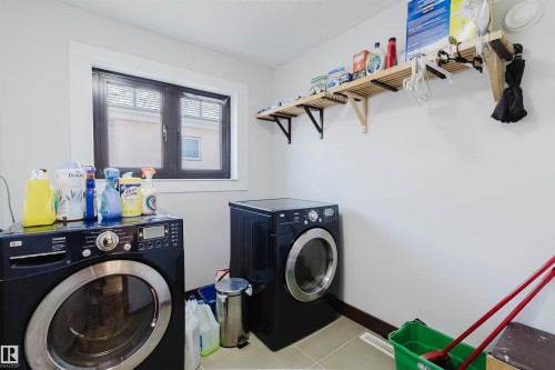 Dedicated laundry area featuring a front-load washer and dryer set - 4103 Westcliff Heath Heath Sw, Edmonton, AB - Indoor Photo Showing Laundry Room