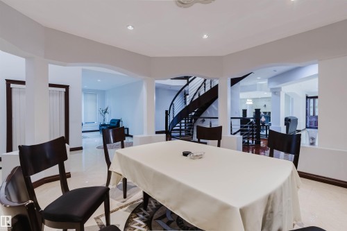 Open-concept dining area featuring light-colored tile flooring with a decorative inlay - 4103 Westcliff Heath Heath Sw, Edmonton, AB - Indoor