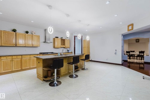 Spacious open-concept kitchen featuring light wood cabinetry, a central island with integrated seating, and recessed lighting - 4103 Westcliff Heath Heath Sw, Edmonton, AB - Indoor