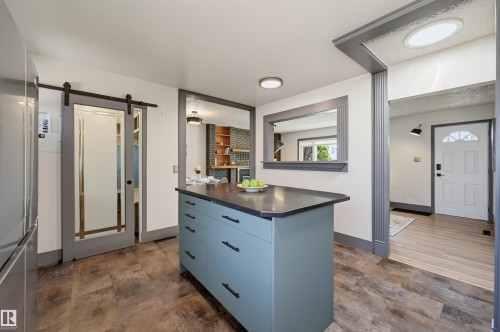 Central kitchen island with ample storage and a dark countertop - 8716 130 Avenue Nw, Edmonton, AB - Indoor
