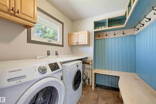 Utility space featuring a front-loading washer and dryer, a built-in bench, and coat hooks - 8716 130 Avenue Nw, Edmonton, AB - Indoor Photo Showing Laundry Room