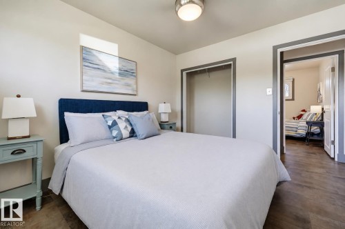 Bedroom featuring wood-finish flooring, a contemporary flush-mount ceiling light, and an open closet space - 8716 130 Avenue Nw, Edmonton, AB - Indoor Photo Showing Bedroom