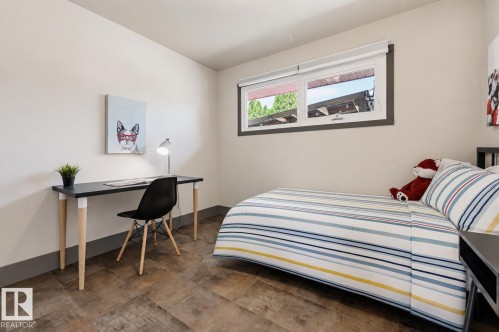 Room featuring wood-finish flooring, white walls, and a low-profile window with dark trim - 8716 130 Avenue Nw, Edmonton, AB - Indoor Photo Showing Bedroom
