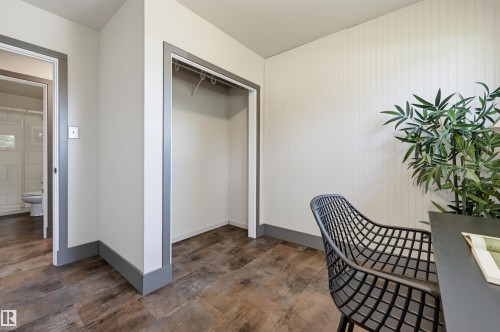 Room featuring wood-finish flooring, white walls, and a built-in closet with a hanging rod - 8716 130 Avenue Nw, Edmonton, AB - Indoor