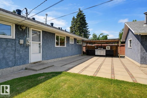 Expansive paved patio with a covered outdoor kitchen featuring a built-in grill and cabinetry - 8716 130 Avenue Nw, Edmonton, AB - Outdoor