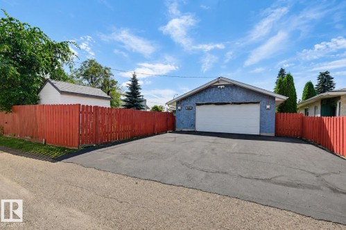 Detached garage with a white overhead door and textured blue exterior - 8716 130 Avenue Nw, Edmonton, AB - Outdoor