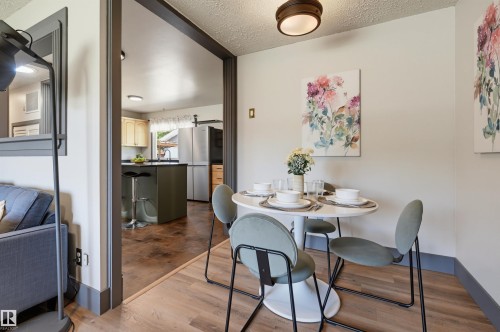 Dining area featuring wood-finish flooring and a ceiling-mounted light fixture - 8716 130 Avenue Nw, Edmonton, AB - Indoor Photo Showing Dining Room