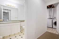 Bathroom vanity with a single sink, light-toned countertop, and mirror - 