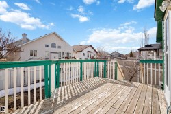 Spacious outdoor deck with a wood surface and white and green railing - 