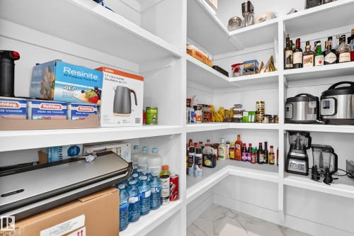 Expansive walk-in pantry featuring white shelving, a white baseboard, and a patterned floor - 22270 99A Avenue Nw, Edmonton, AB - Indoor With Storage