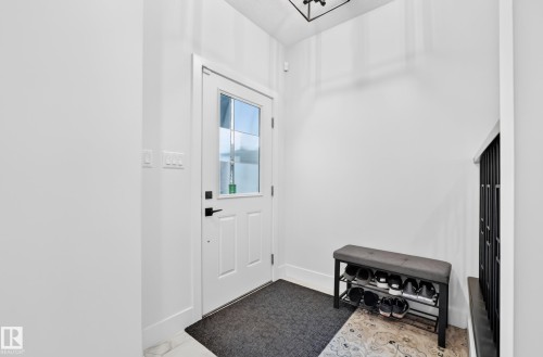 Entryway featuring a white door with a clear glass insert, a dark hardware handle, and a decorative tile flooring accent - 22270 99A Avenue Nw, Edmonton, AB - Indoor Photo Showing Other Room