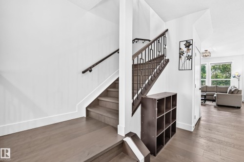 Hardwood-finish flooring throughout the entryway and visible living space - 22270 99A Avenue Nw, Edmonton, AB - Indoor Photo Showing Other Room