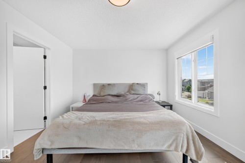 Bedroom featuring wood-finish flooring and a large window with white trim - 22270 99A Avenue Nw, Edmonton, AB - Indoor Photo Showing Bedroom