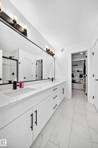 Double vanity featuring white cabinetry, integrated sinks, and black hardware - 22270 99A Avenue Nw, Edmonton, AB - Indoor Photo Showing Bathroom