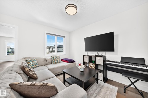 Living area with wood-finish flooring, white walls, and a large window - 22270 99A Avenue Nw, Edmonton, AB - Indoor Photo Showing Living Room