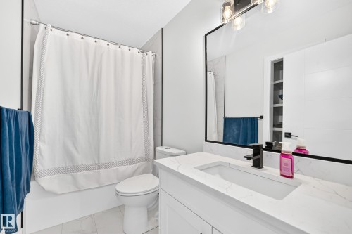 Contemporary bathroom featuring a white vanity with a rectangular undermount sink and a stone-finish countertop - 22270 99A Avenue Nw, Edmonton, AB - Indoor Photo Showing Bathroom