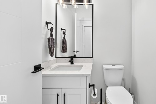 Bathroom featuring a white vanity with a rectangular sink, a light-colored countertop, and a matte black faucet - 22270 99A Avenue Nw, Edmonton, AB - Indoor Photo Showing Bathroom