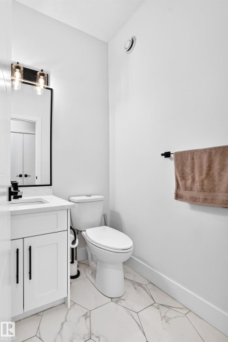 White vanity with integrated sink, black hardware, and hexagonal floor tiling - 22270 99A Avenue Nw, Edmonton, AB - Indoor Photo Showing Bathroom
