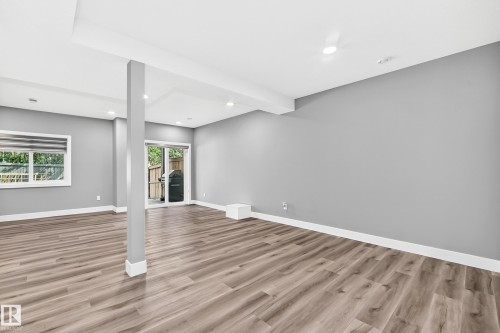 Spacious room featuring wood-finish flooring, recessed lighting, a large window, and sliding glass doors providing outdoor access - 22270 99A Avenue Nw, Edmonton, AB - Indoor Photo Showing Other Room