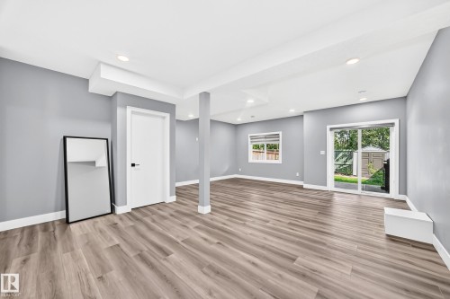 Spacious room featuring wood-finish flooring, recessed lighting, and light gray walls - 22270 99A Avenue Nw, Edmonton, AB - Indoor Photo Showing Other Room