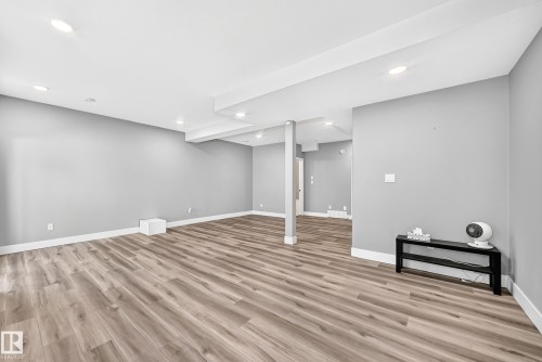 Spacious open area featuring wood-finish flooring, recessed lighting, and light grey wall finishes - 22270 99A Avenue Nw, Edmonton, AB - Indoor
