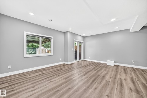 Spacious room featuring wood-finish flooring, recessed lighting, and a sliding glass door - 22270 99A Avenue Nw, Edmonton, AB - Indoor Photo Showing Other Room