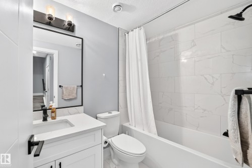Full bathroom featuring a white vanity with a rectangular undermount sink, quartz countertop, and matte black fixtures - 22270 99A Avenue Nw, Edmonton, AB - Indoor Photo Showing Bathroom