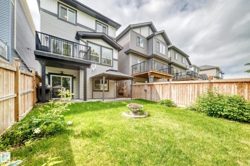 Expansive green lawn with a fire pit feature, surrounded by a wooden fence - 22270 99A Avenue Nw, Edmonton, AB - Outdoor