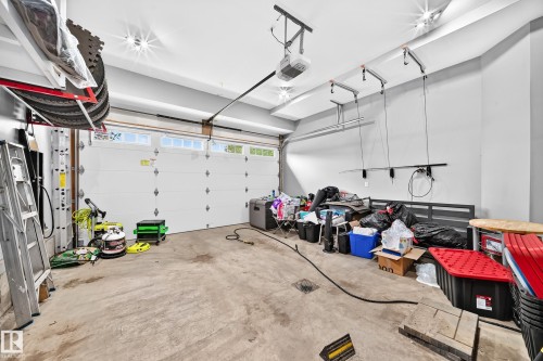 Spacious garage featuring a concrete floor, overhead lighting, and a white paneled garage door with upper window inserts - 22270 99A Avenue Nw, Edmonton, AB - Indoor Photo Showing Garage