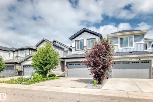 Modern facade featuring horizontal and vertical siding, a two-car garage, and established landscaping - 22270 99A Avenue Nw, Edmonton, AB - Outdoor With Facade