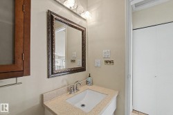 Bathroom vanity featuring a light-toned countertop, undermount sink, and polished chrome faucet - 